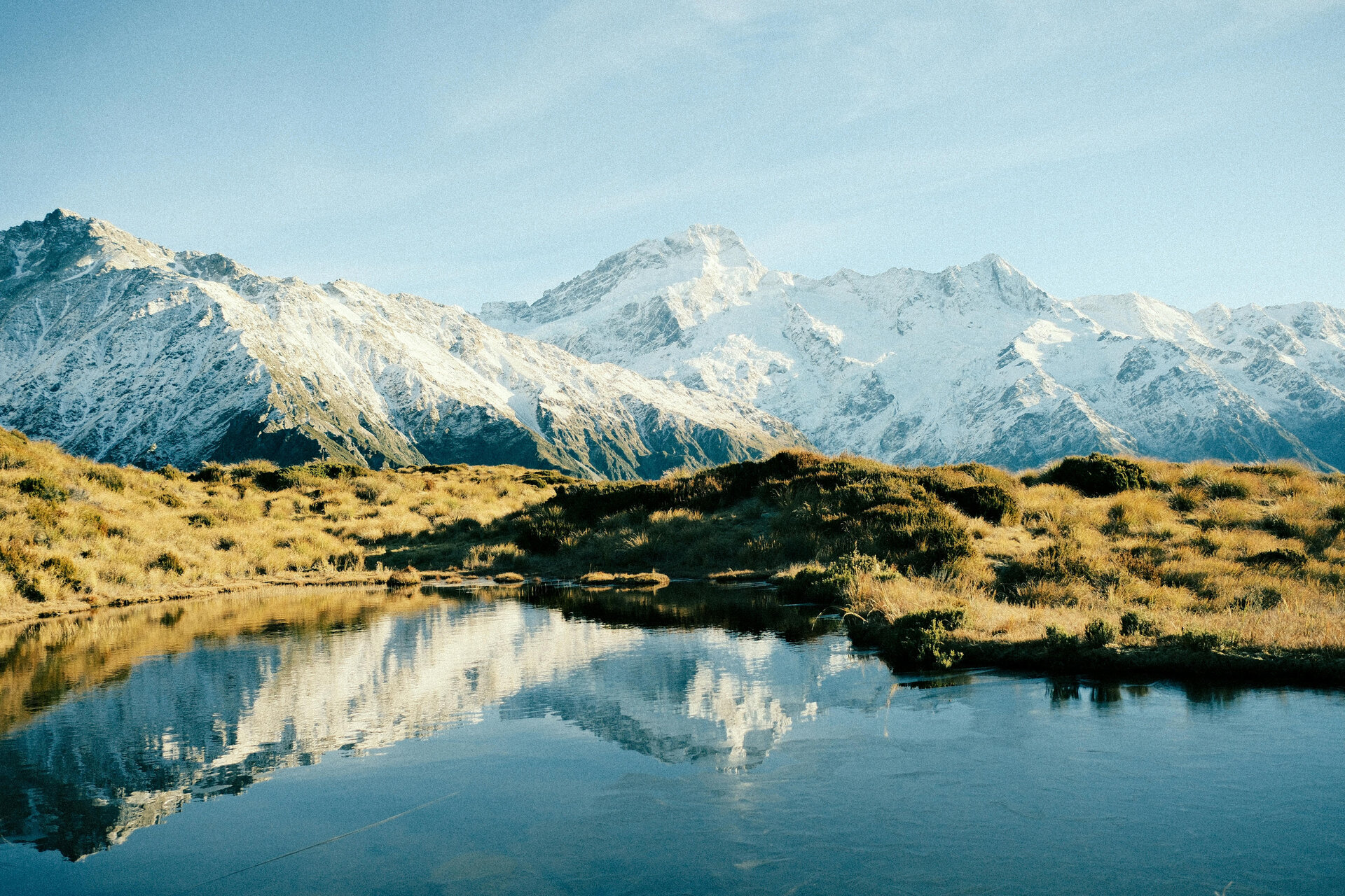 Snowy Southern Alps reflected in a mountain lake in New Zealand